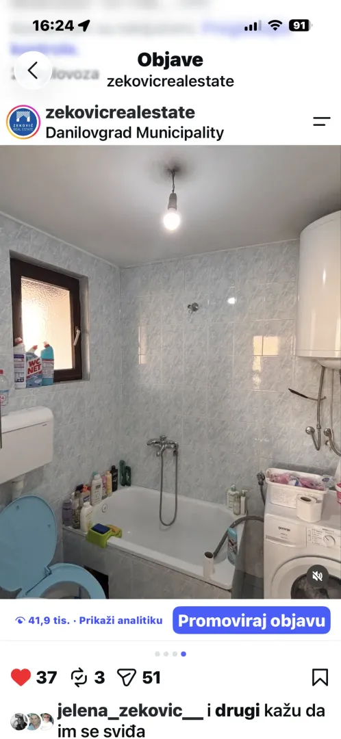 Manje opremljeno kupatilo sa kadom, pločicama i veš mašinom.