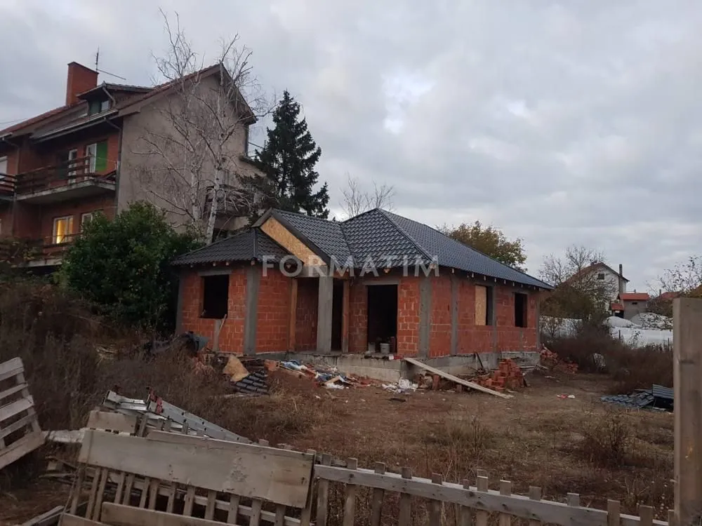Pogled na kuću u izgradnji sa postavljenim krovom i otvorenim prozorima.