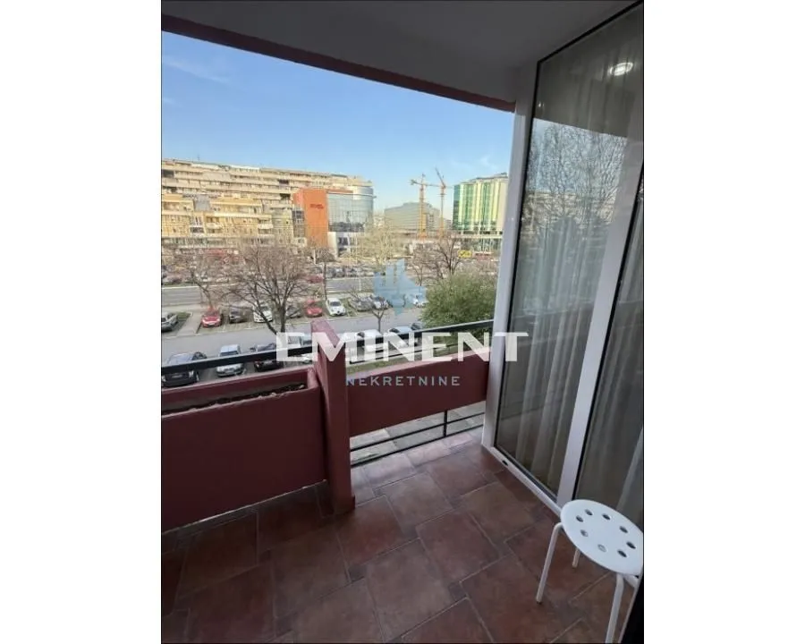 Covered balcony space overlooking the city street and buildings.