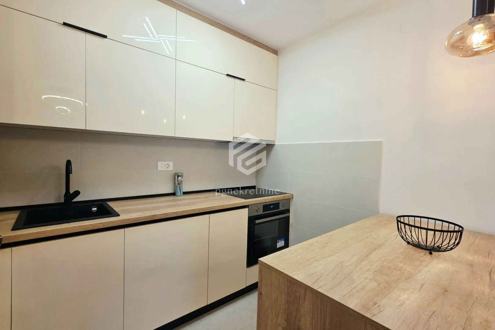 Modern kitchen with white cabinets, wooden countertop and built-in appliances.