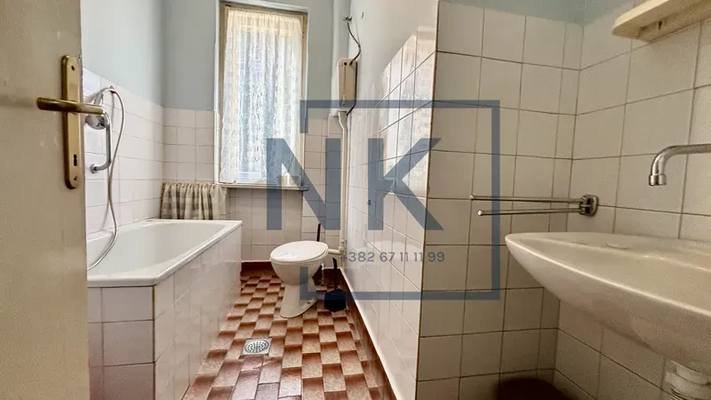 Smaller bathroom with a bathtub, washbasin, and toilet.