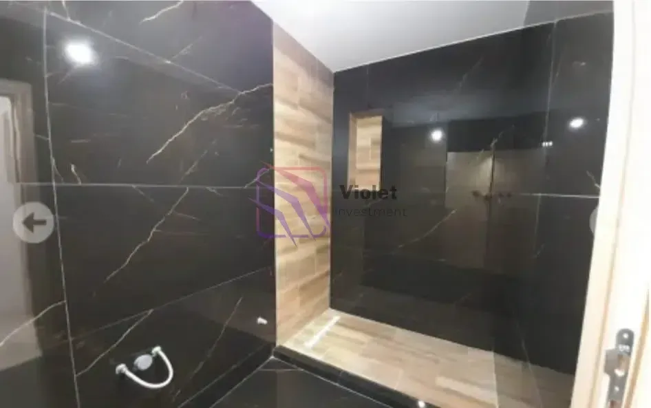 Moderne crne pločice sa efektom mermera u kupatilu.