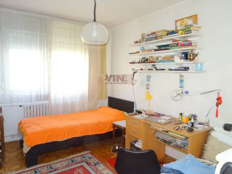 Nameštena spavaća soba sa krevetom, radnim stolom i zidnim policama. - image 6