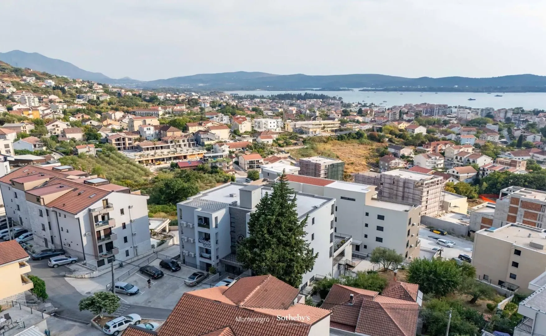 Pogled iz vazduha na stambene zgrade i okolno naselje sa brda.