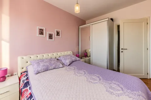 Spavaća soba sa bračnim krevetom, bijelim garderoberom i roze zidom. - image 7
