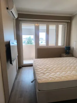 Spavaća soba sa bračnim krevetom, televizorom i izlazom na terasu. - image 4
