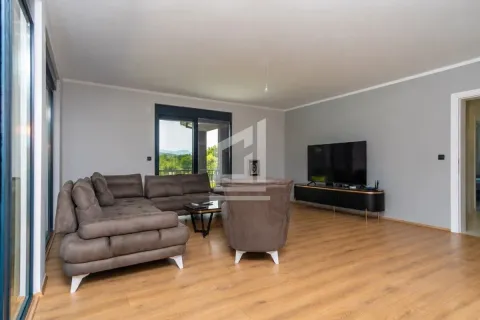 Spacious living room with a sofa, armchair, and TV unit. - image 3