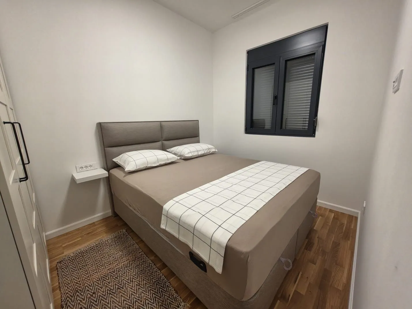Small bedroom with a double bed, wardrobe, and window.