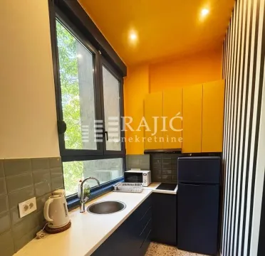 Small kitchen with yellow cabinets and a window next to the sink. - image 9