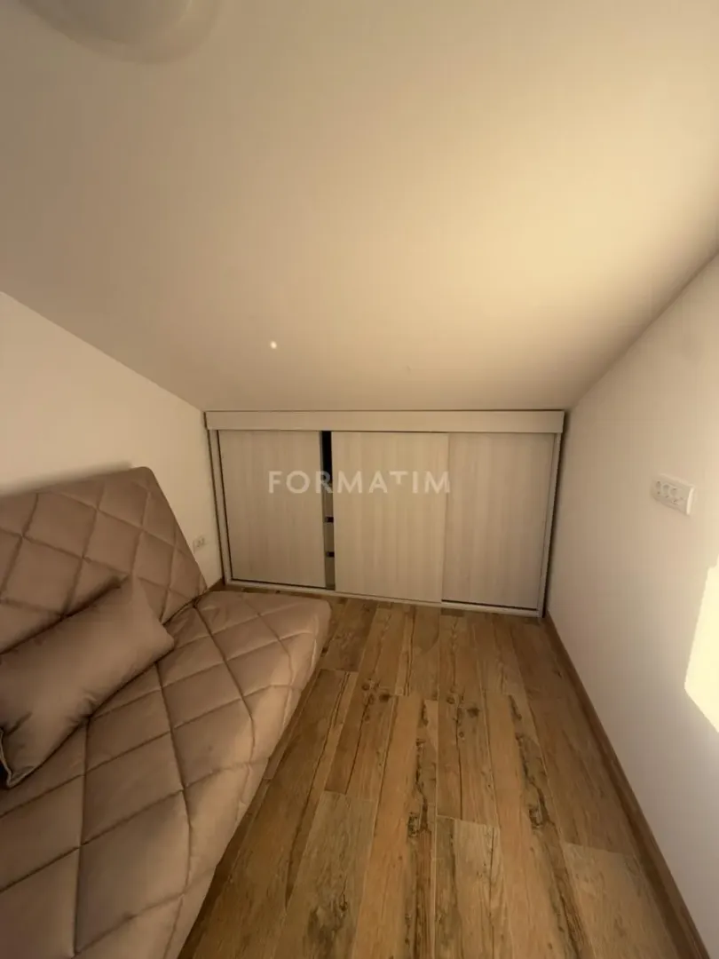 Small room with a sofa and a built-in wardrobe under the sloping roof.