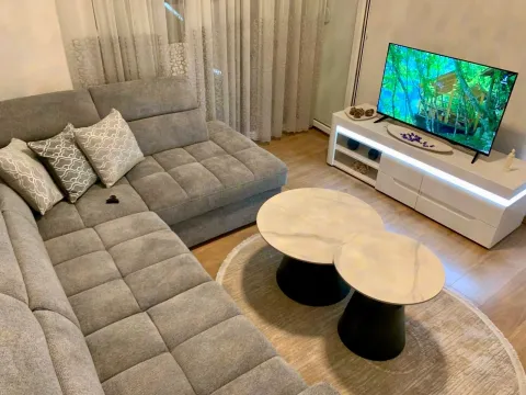 Comfortable living room with a sectional sofa, coffee table, and TV. - image 2