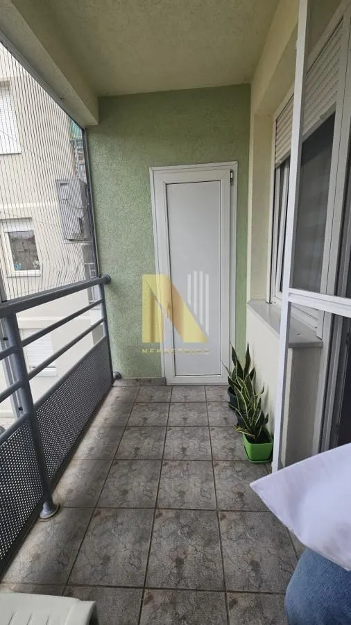 Manji zatvoreni balkon sa keramičkim pločicama i ogradom.