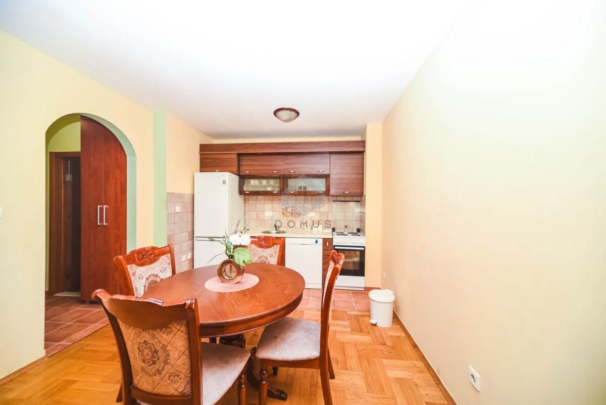 Smaller kitchen with a dining table and wooden cabinets.