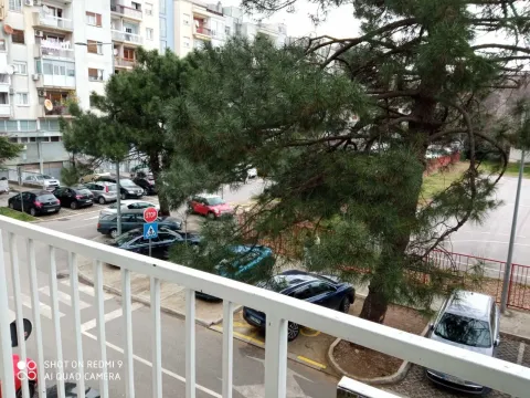 View from a balcony showing a parking lot and surrounding buildings. - image 11
