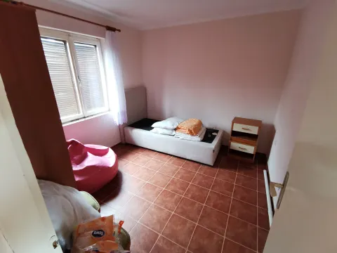Manja spavaća soba sa krevetom, noćnim stočićem i prozorom. - image 4