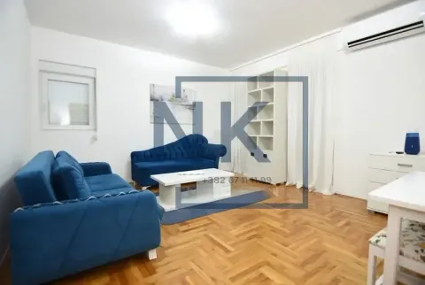 Dnevna soba sa plavom garniturom, stočićem i policom. - image 2