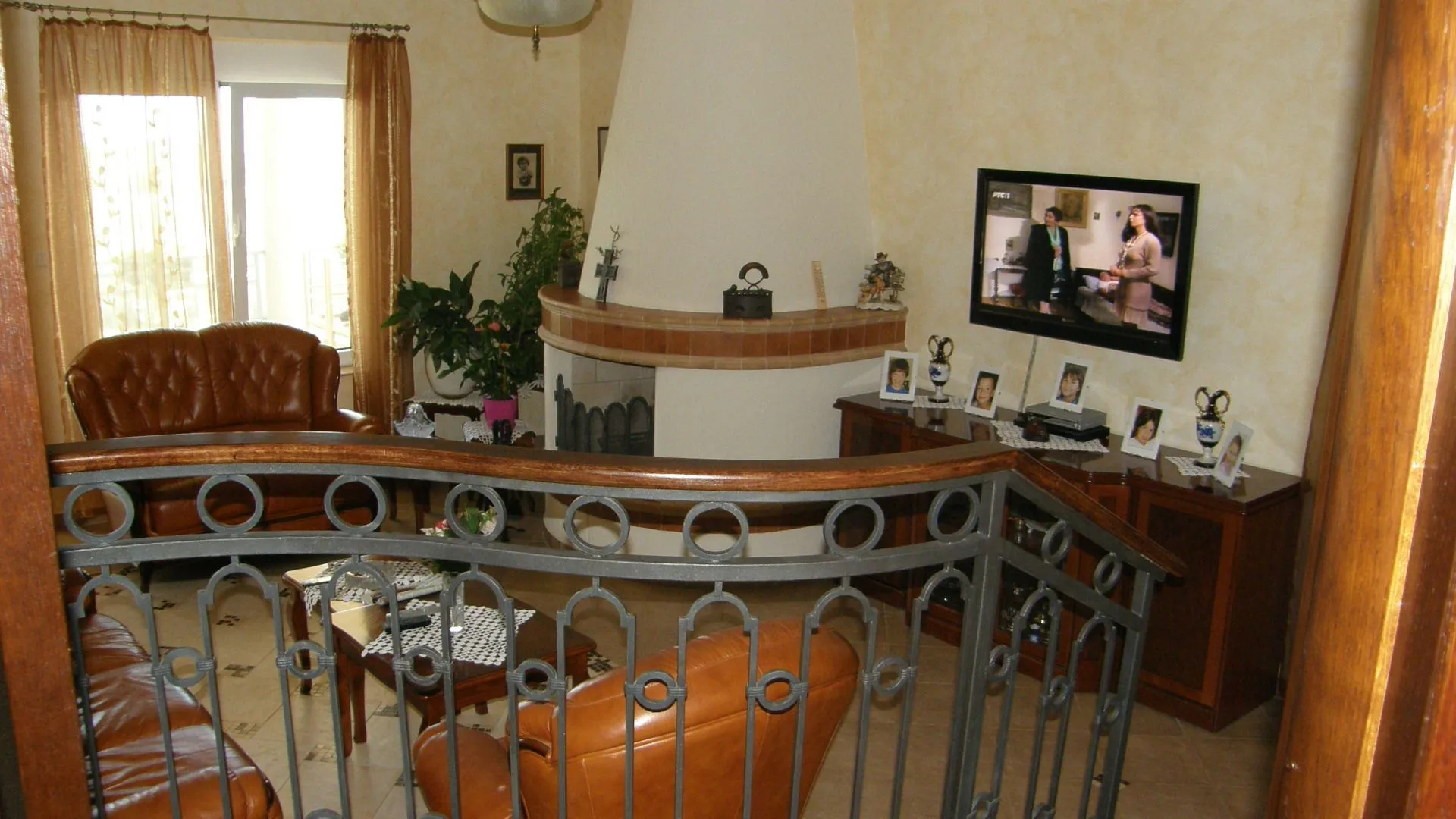 Living room with a fireplace and leather furniture sets.