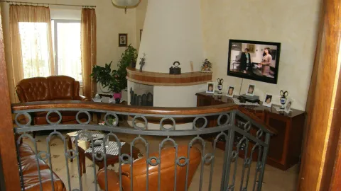 Living room with a fireplace and leather furniture sets. - image 25