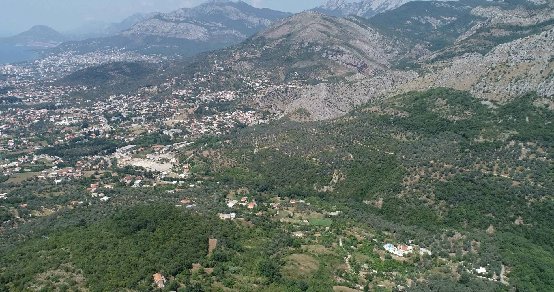 Pogled iz vazduha na brdoviti pejzaž i okolna naselja.