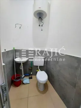 Smaller bathroom with a toilet, washbasin, and water heater. - image 8