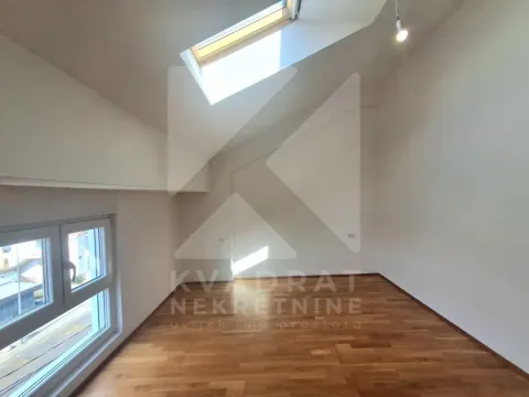 Empty attic room with hardwood flooring and a skylight. - image 8