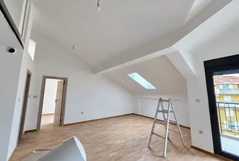 Empty attic room with parquet flooring and a ladder. - image 11