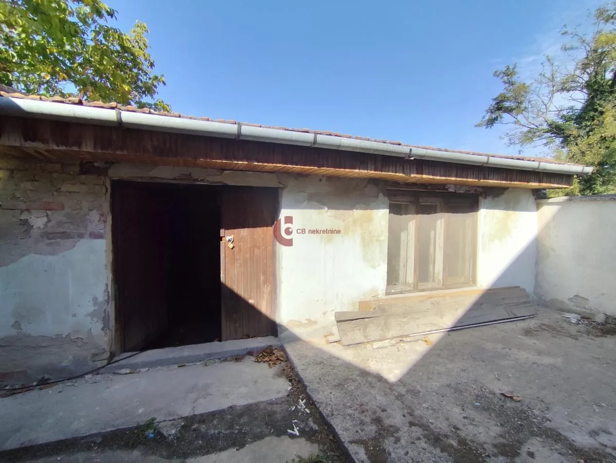 Pogled na eksterijer starije prizemne kuće sa dvorištem.