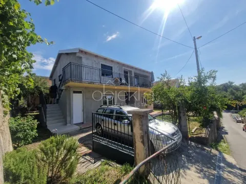 View of the exterior of the house with a yard, terrace, and parked car. - image 2
