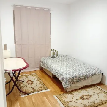 Smaller bedroom with a bed, a small table, and rugs. - image 4