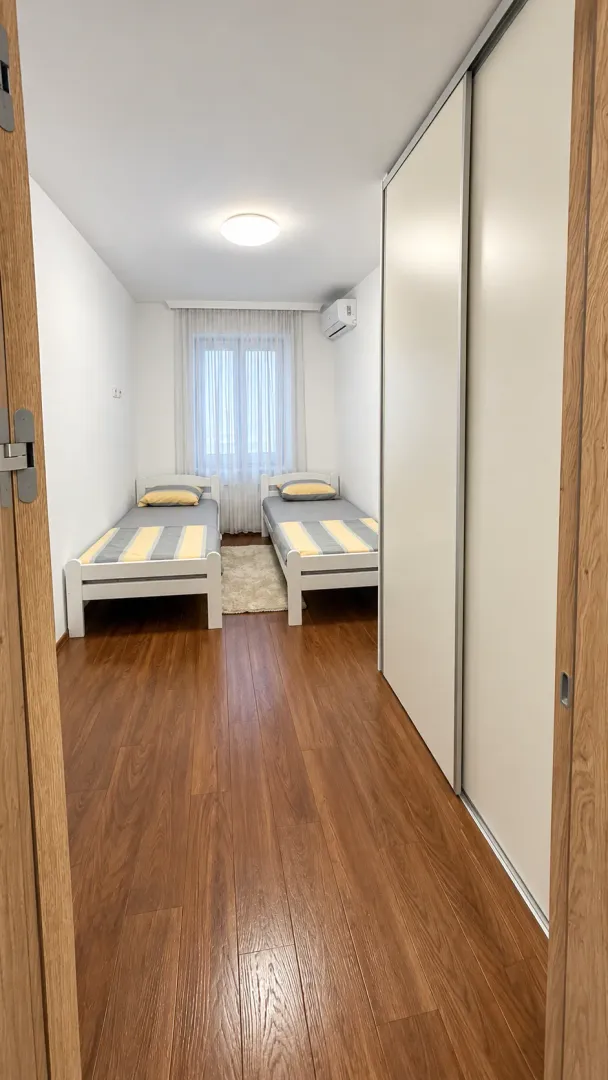 Small bedroom with two single beds and a large built-in wardrobe.