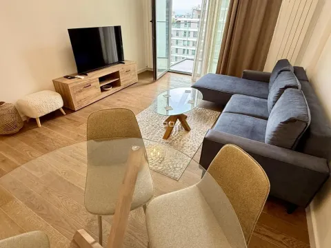 Living room with a sofa, TV, and dining table. - image 3
