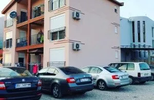 Exterior view of an apartment building with parking in front.
