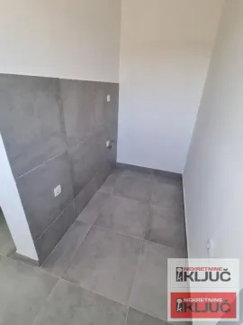 Unfinished bathroom with grey tiles on the wall and floor. - image 8