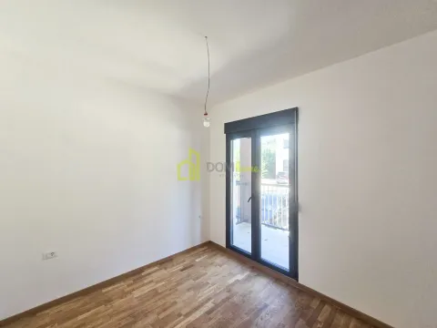Prazna soba sa bijelim zidovima, drvenim podom i izlazom na terasu. - image 7