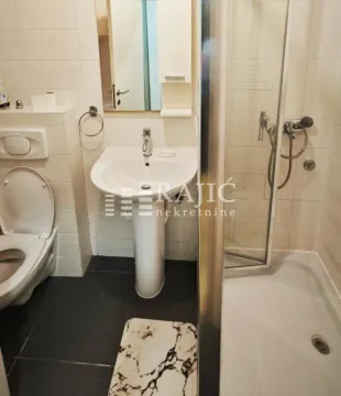 Small bathroom with a sink, toilet, and shower cabin. - image 6
