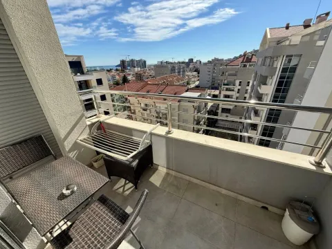 Furnished balcony with seating set and a view of the city and the sea. - image 7