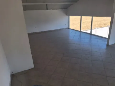 View of an empty room with tiled flooring and large windows. - image 6