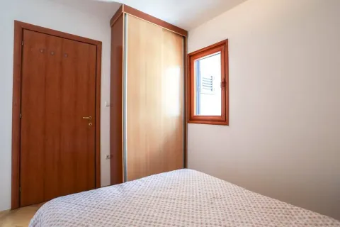 Small bedroom with a bed, wardrobe, and wooden doors. - image 6