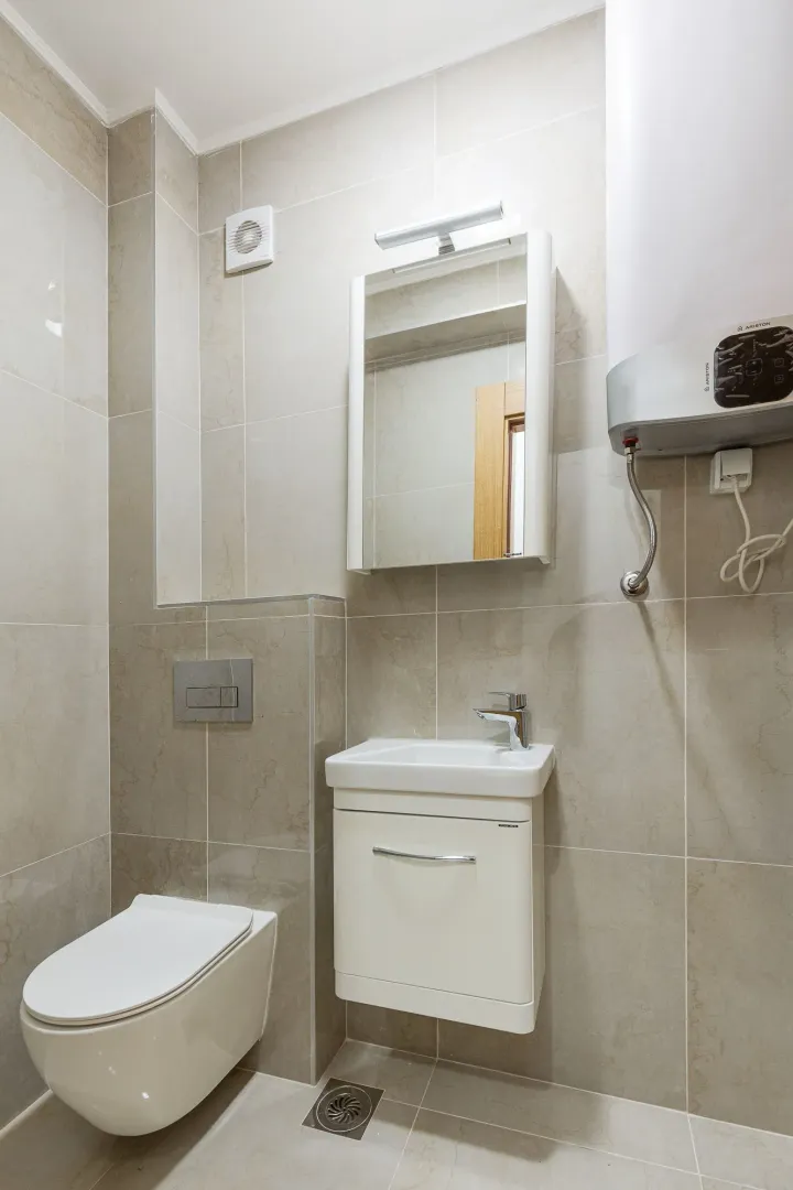 Kompaktno kupatilo opremljeno umivaonikom, WC šoljom i bojlerom.