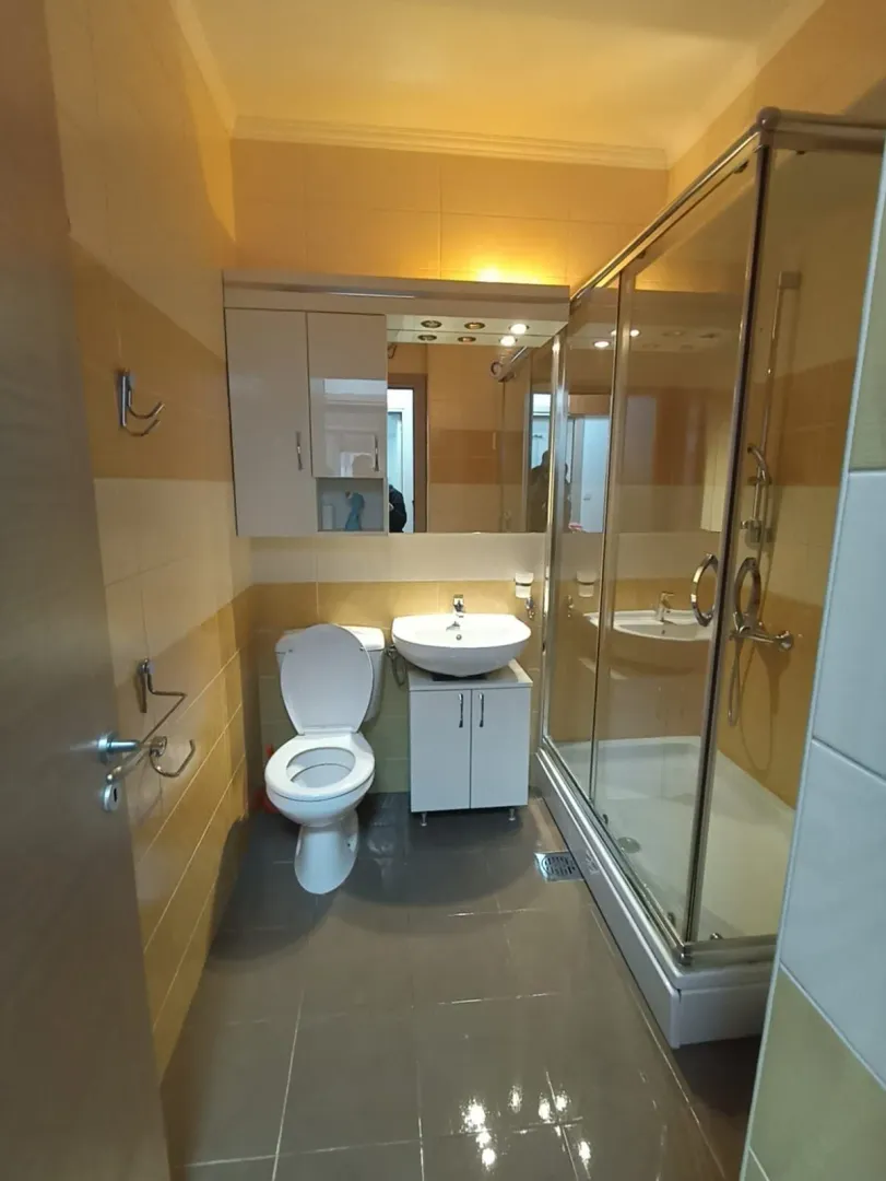 Small bathroom with a shower cabin, washbasin, and toilet.