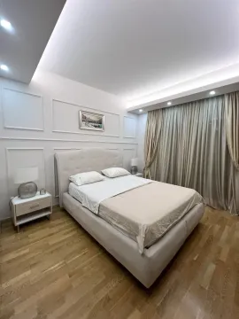 Furnished bedroom with a double bed, wooden flooring, and recessed lighting. - image 5