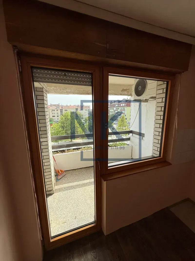 Wooden balcony doors and a window with access to the terrace.