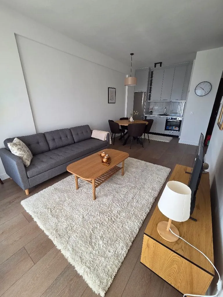 Living room with sofa and dining area in an open-plan space.