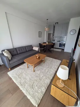Living room with sofa and dining area in an open-plan space. - image 2