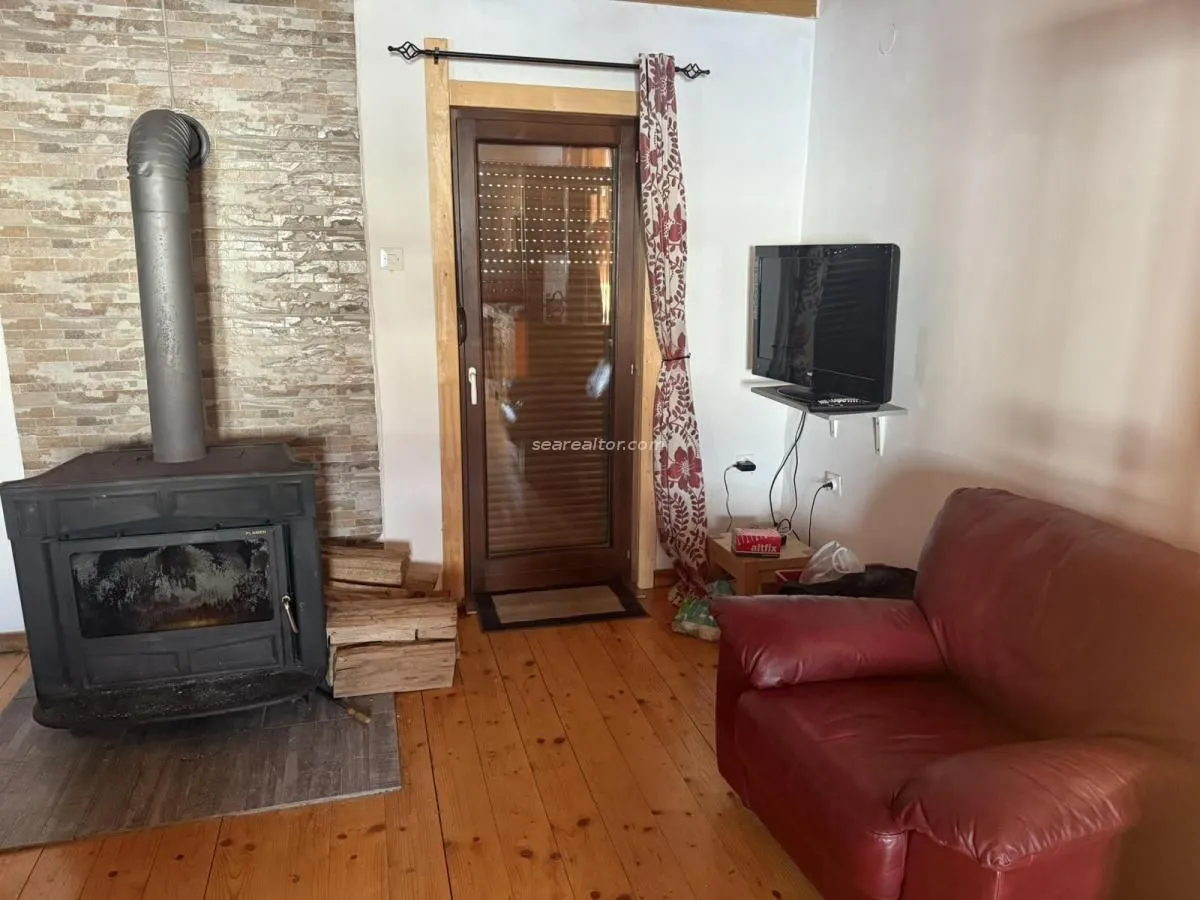 Living room with a wood-burning stove and wooden flooring.