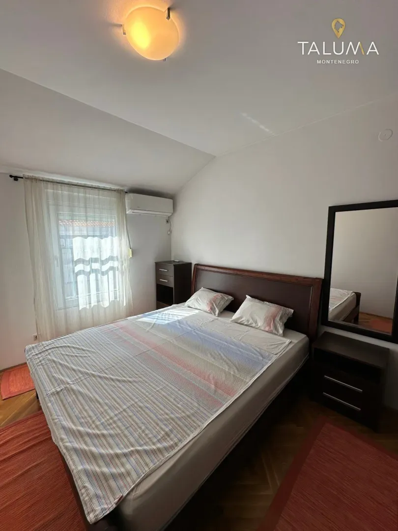 Bedroom with a double bed, nightstand, and a mirror.