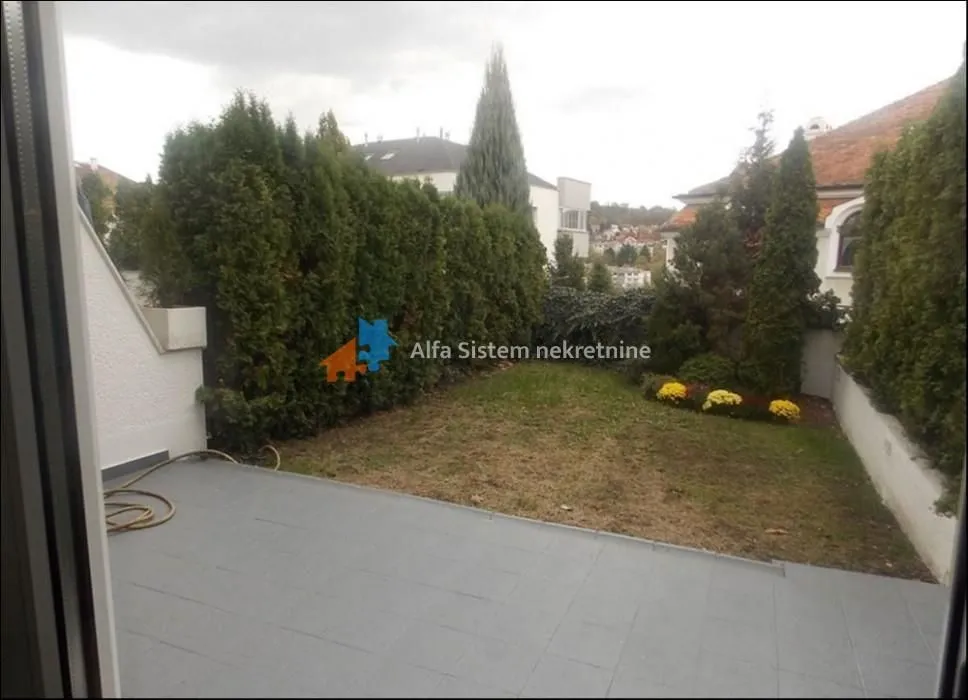 Terrace overlooking the landscaped yard and greenery.