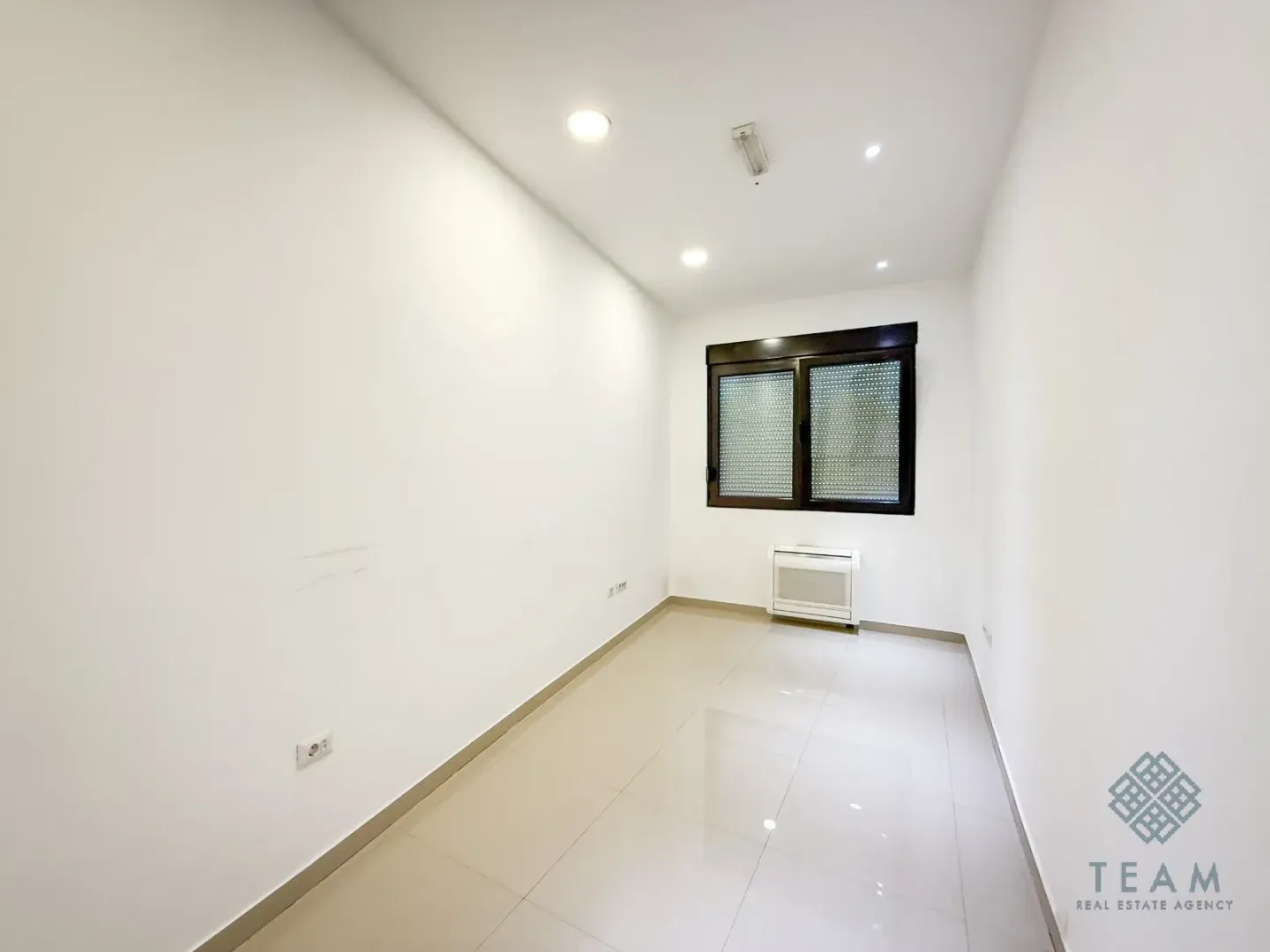 Empty bright room with tiled floors and a window.