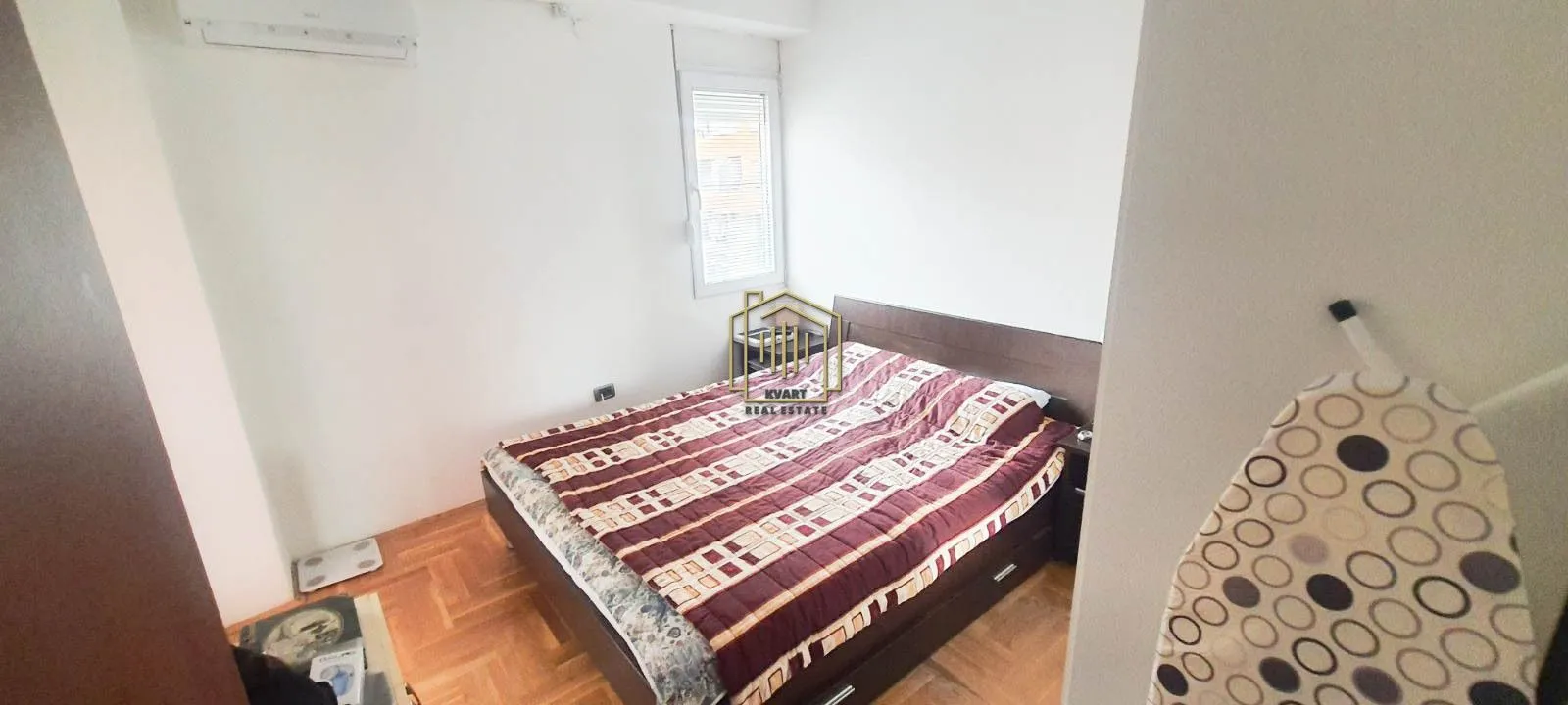 Small bedroom with a double bed and parquet flooring.