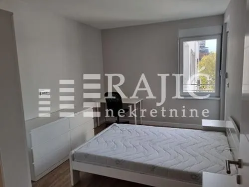 Furnished bedroom with a double bed, a desk, and a white chest of drawers.
